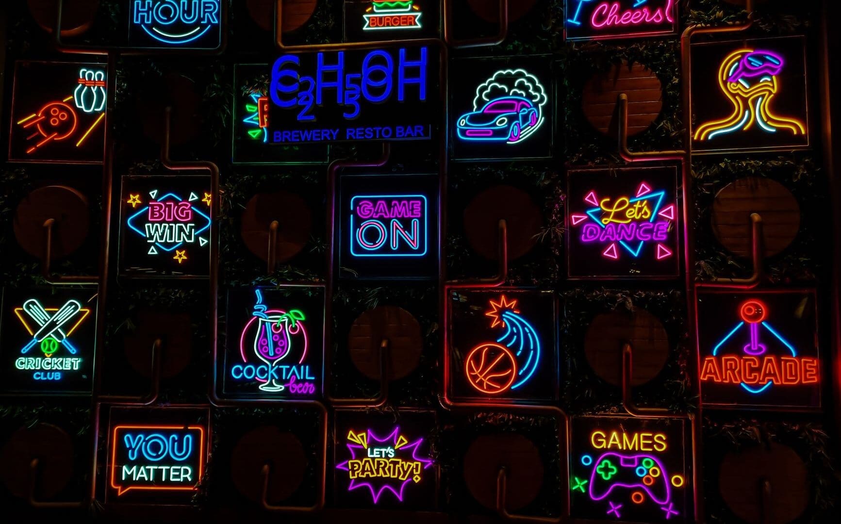 Neon signs for cocktails and gaming at a barcade in Texas