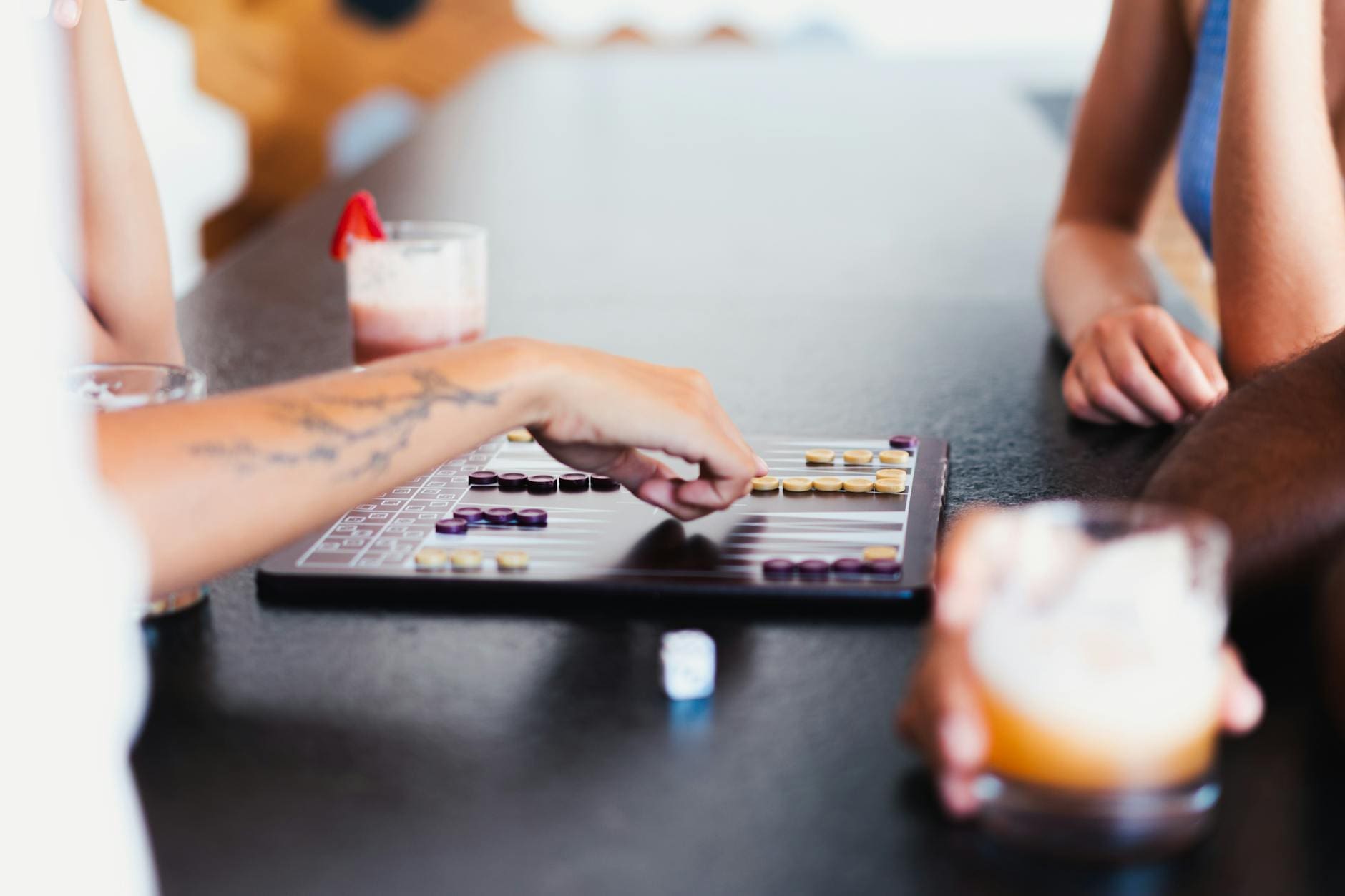 People playing board games at a bar with drinks