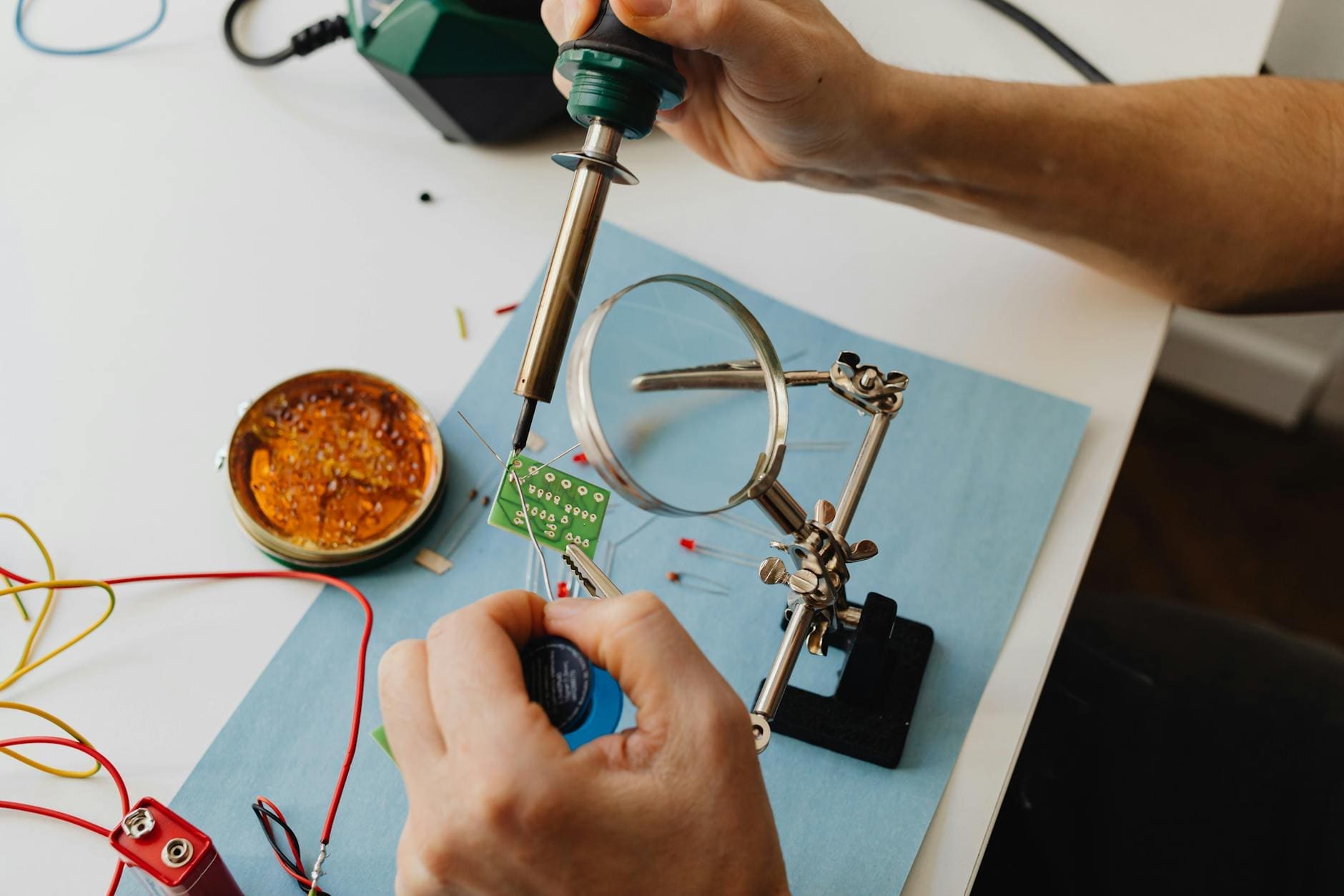 Person working with electronics and tech tools in a workshop